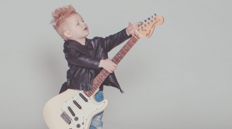NIño pequeño sosteniendo una guitarra eléctrica