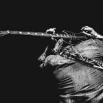 Hombre tocando la guitarra en su espalda