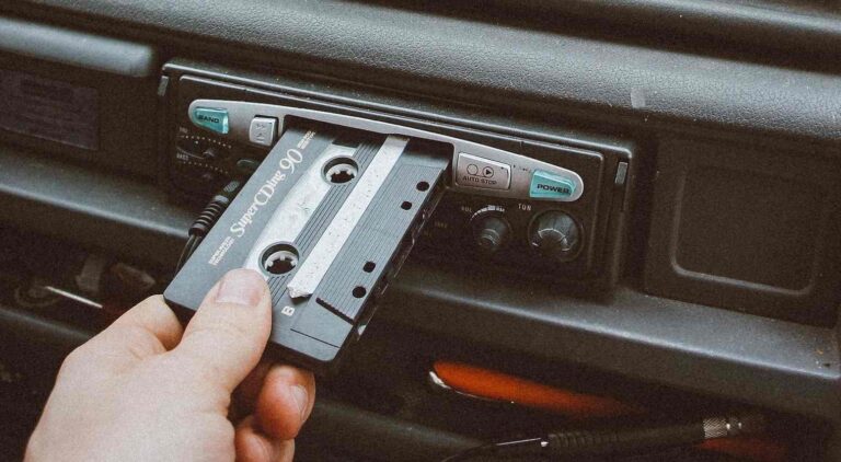 Persona metiendo un cassete en el reproductor del coche
